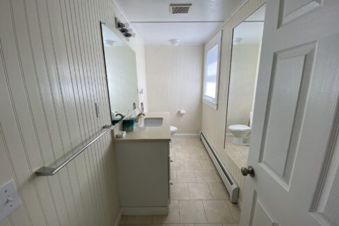 a bathroom with a sink, mirror and toilet.