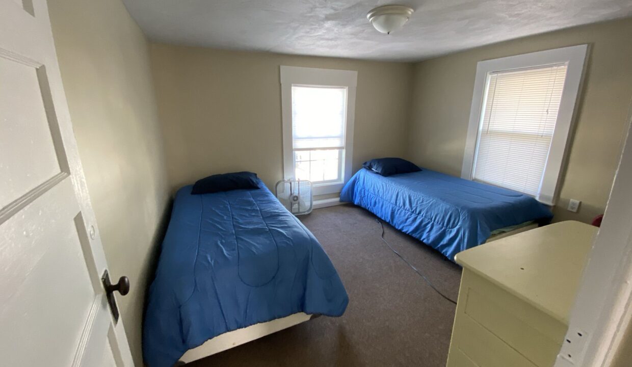 a bedroom with two beds and a dresser.