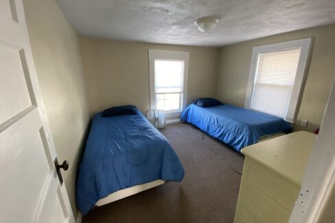 a bedroom with two beds and a dresser.