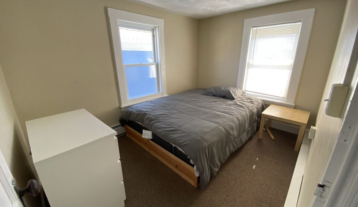 a bedroom with a bed and two windows.