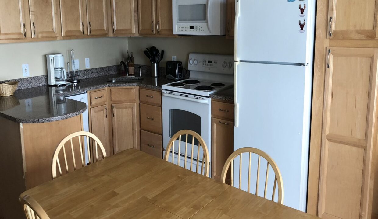 a kitchen with wooden cabinets and a white refrigerator.