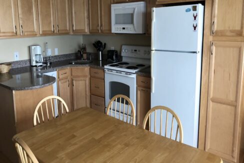 a kitchen with wooden cabinets and a white refrigerator.