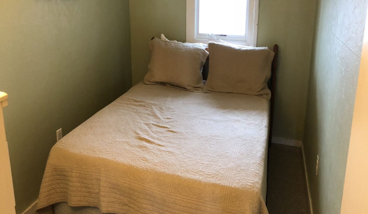 a bed sitting in a bedroom next to a window.