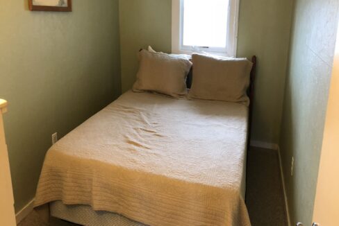 a bed sitting in a bedroom next to a window.