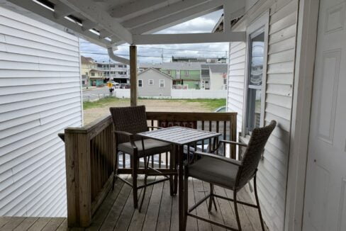 a porch with a table and chairs on it.