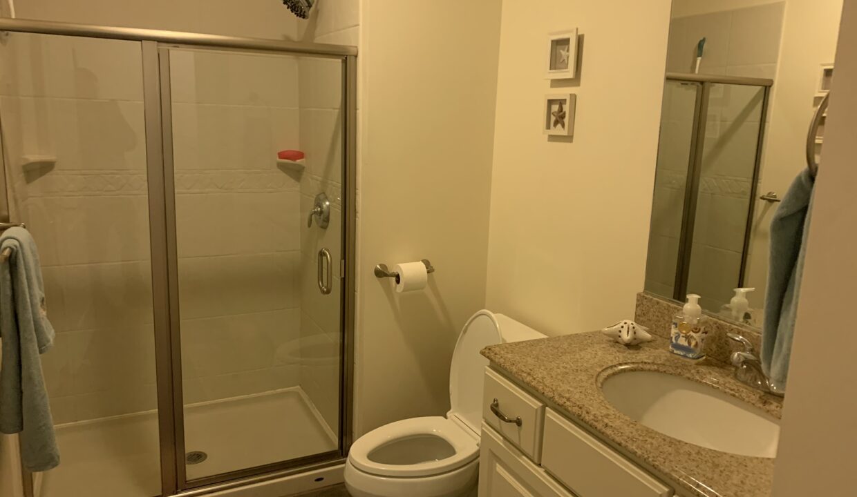 a bathroom with a sink, toilet, and shower.