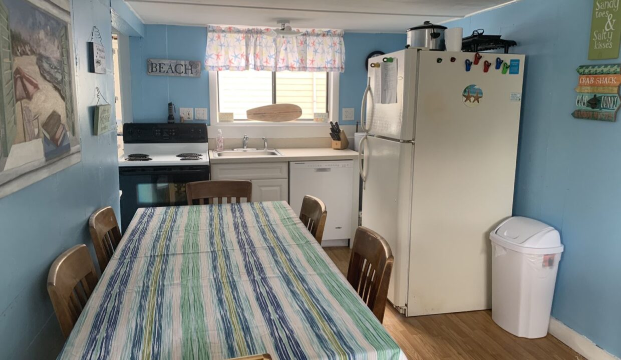 a kitchen with a table and a refrigerator.