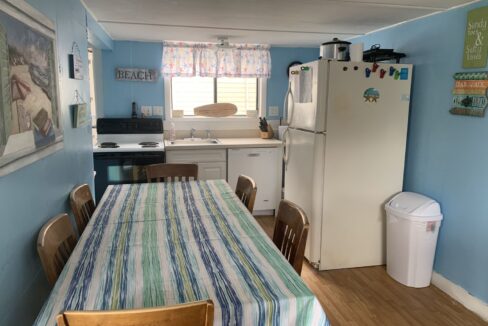 a kitchen with a table and a refrigerator.