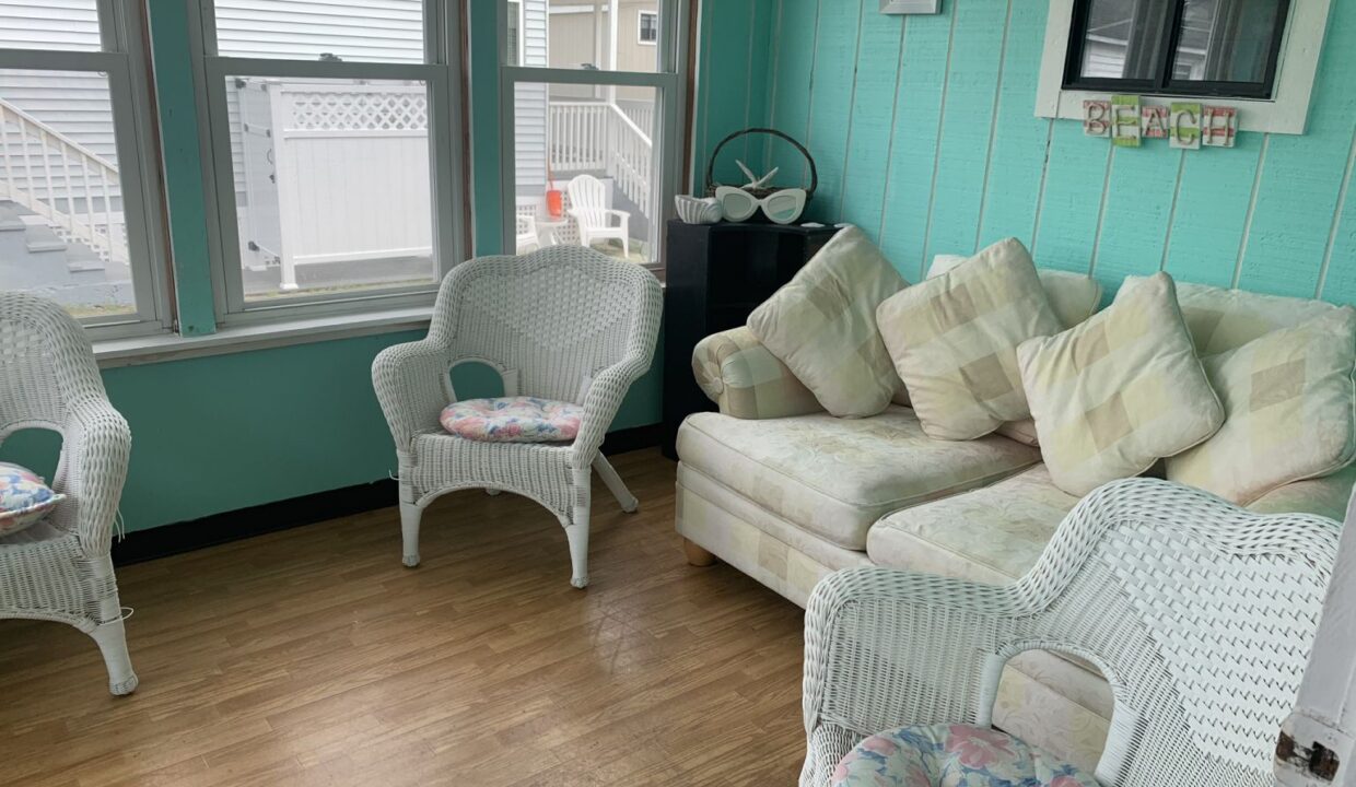 a living room filled with white wicker furniture.