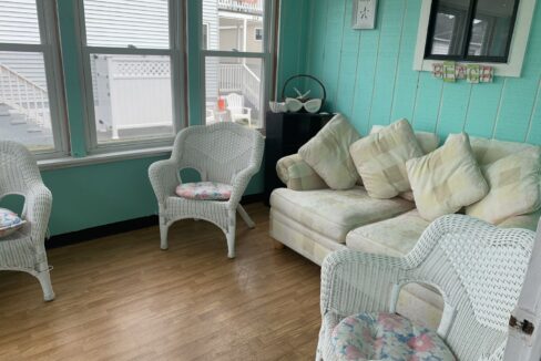 a living room filled with white wicker furniture.