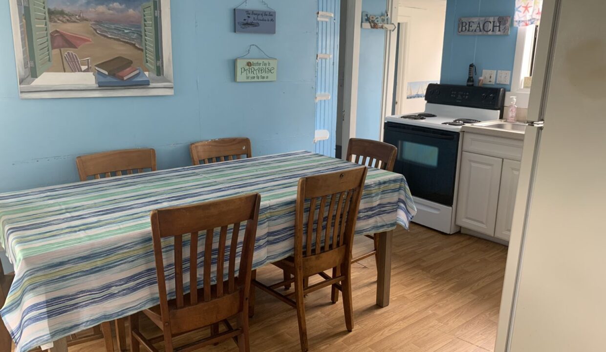 a kitchen with a table and chairs and a refrigerator.