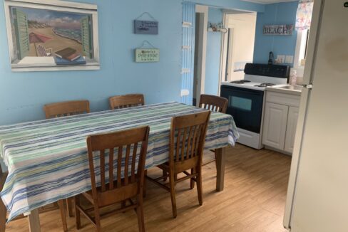 a kitchen with a table and chairs and a refrigerator.