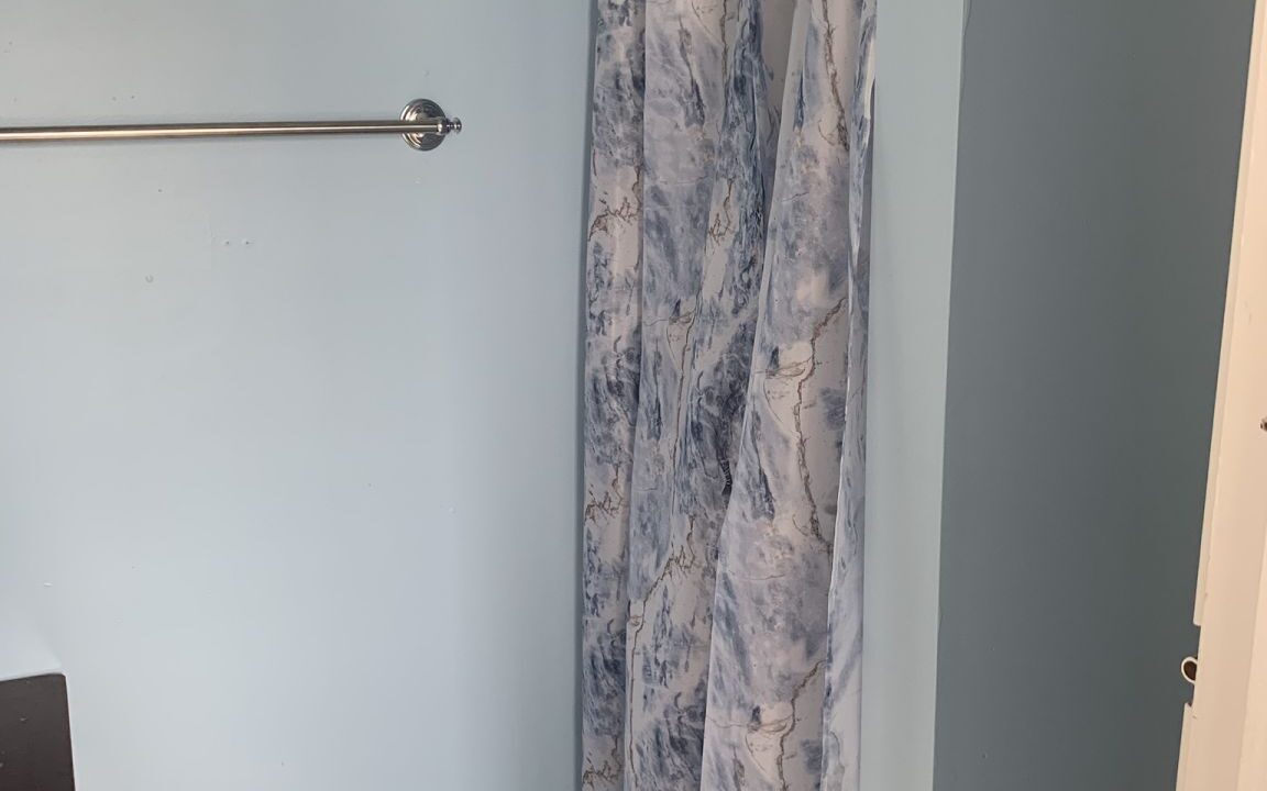 a bathroom with blue walls and a shower curtain.