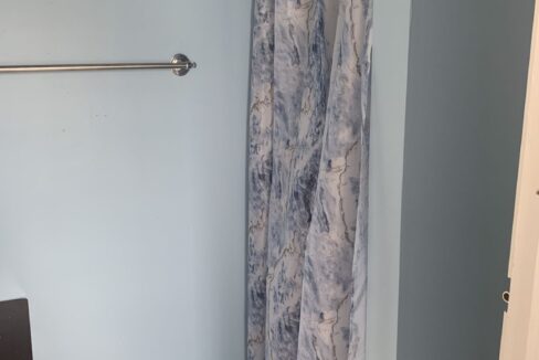 a bathroom with blue walls and a shower curtain.