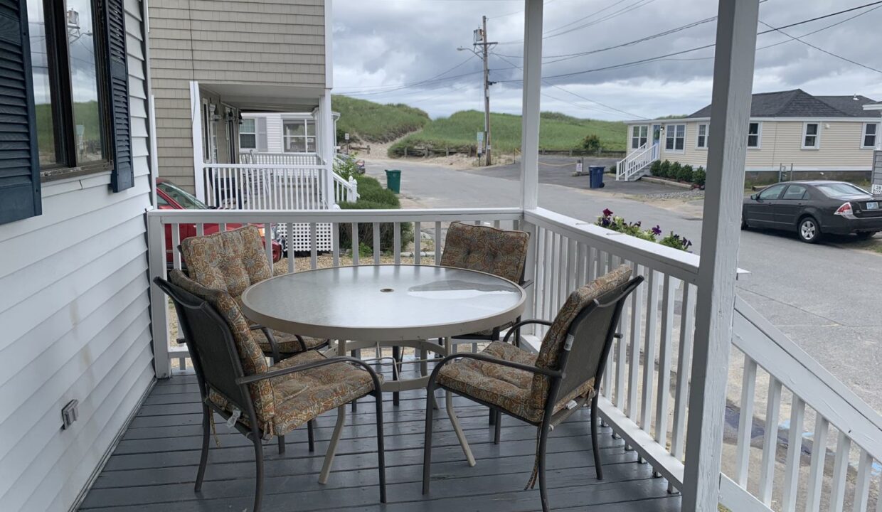 a porch with a table and chairs on it.