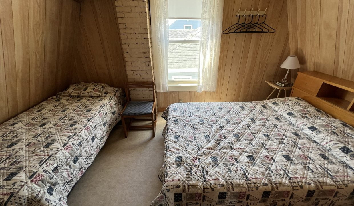 a bedroom with two beds and a window.