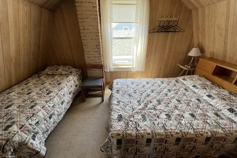 a bedroom with two beds and a window.