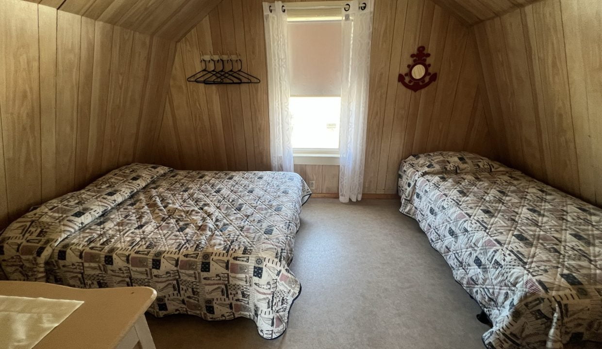 a bedroom with two beds and a window.