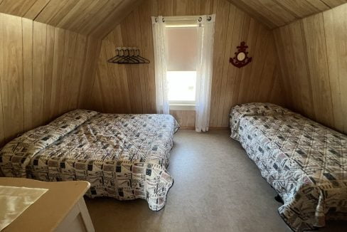 a bedroom with two beds and a window.