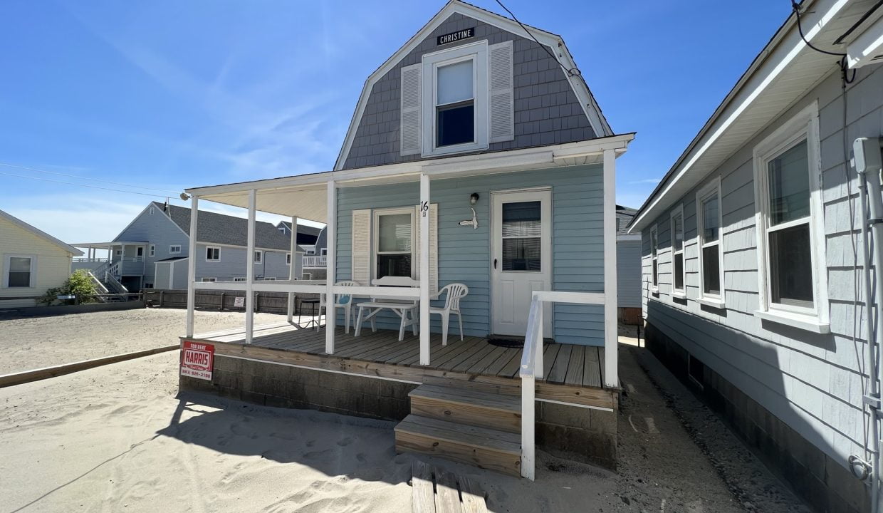 a small house with a porch and steps leading to the front door.