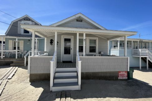 a white house with a porch and stairs.