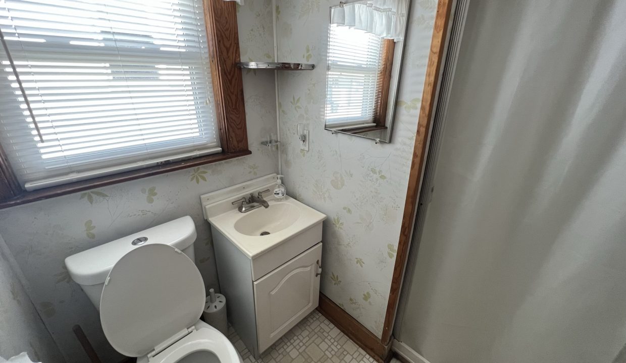 a white toilet sitting next to a white sink.