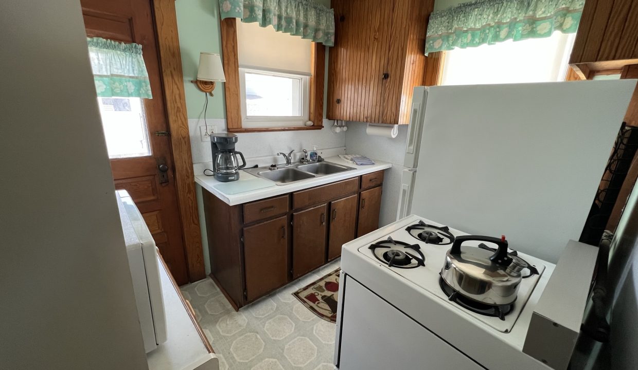 a kitchen with a stove top oven next to a refrigerator.