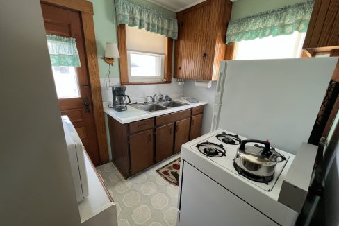 a kitchen with a stove top oven next to a refrigerator.