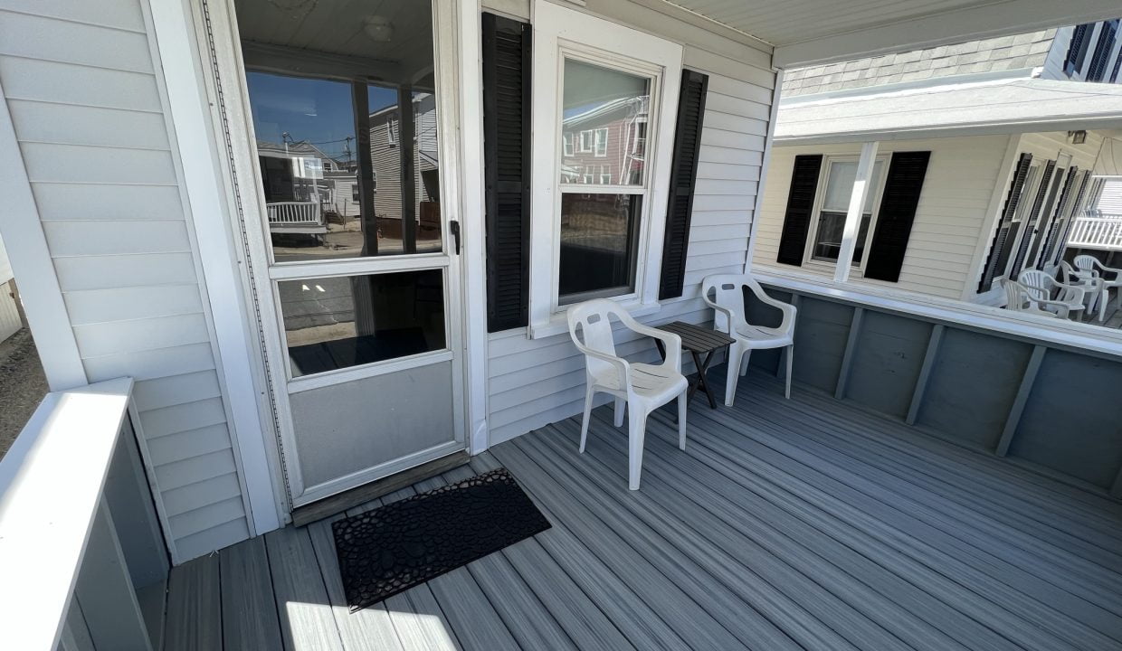 a porch with chairs and a table on it.