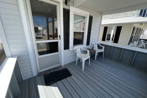 a porch with chairs and a table on it.