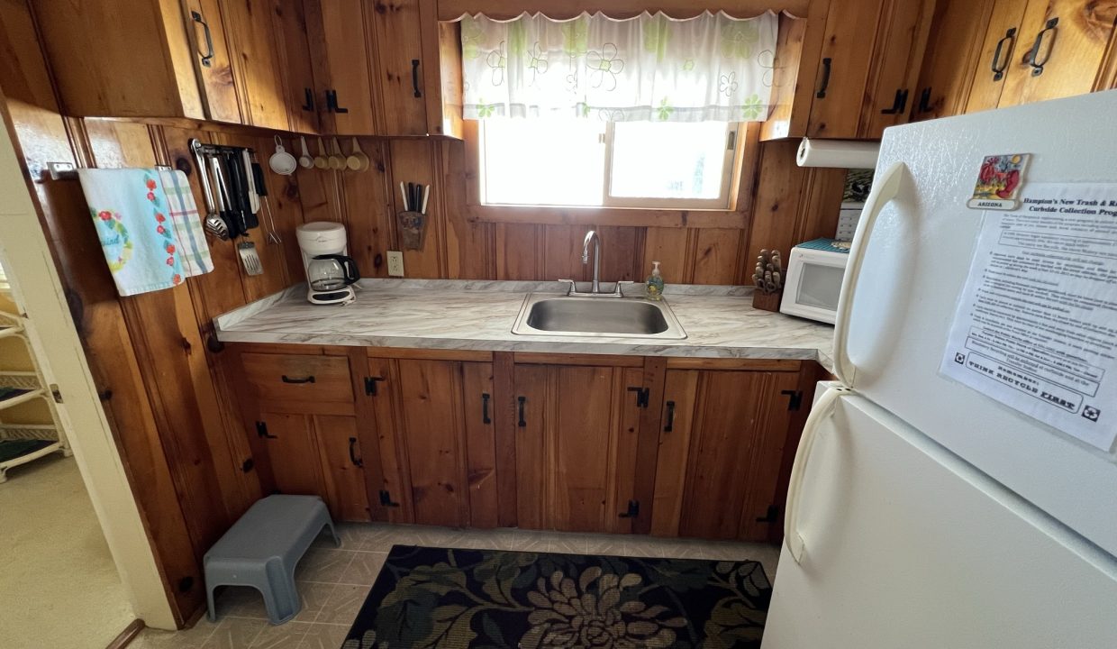 a kitchen with wood paneling and a white refrigerator.