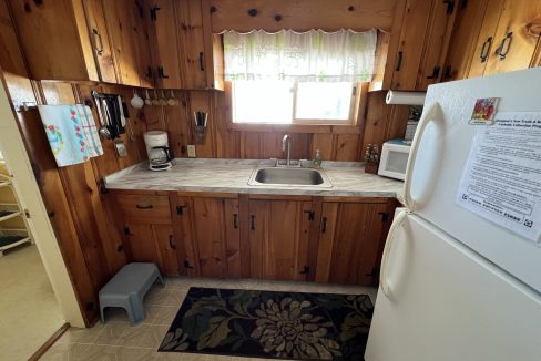 a kitchen with wood paneling and a white refrigerator.