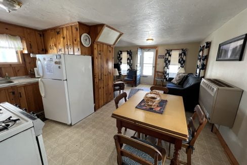 a kitchen with a table, refrigerator and stove.