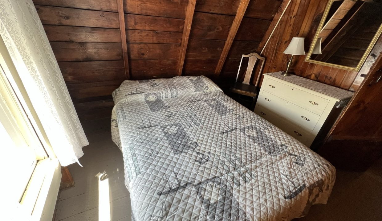 a bed sitting in a bedroom next to a window.