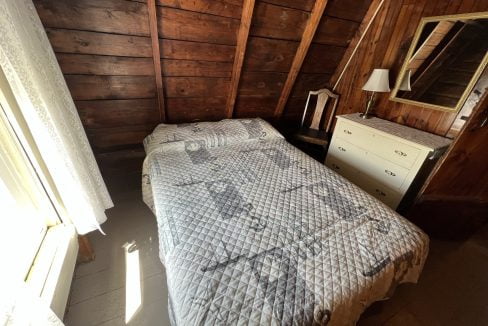 a bed sitting in a bedroom next to a window.