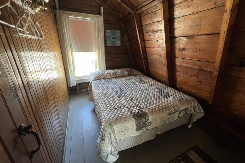 a bed sitting in a bedroom next to a window.