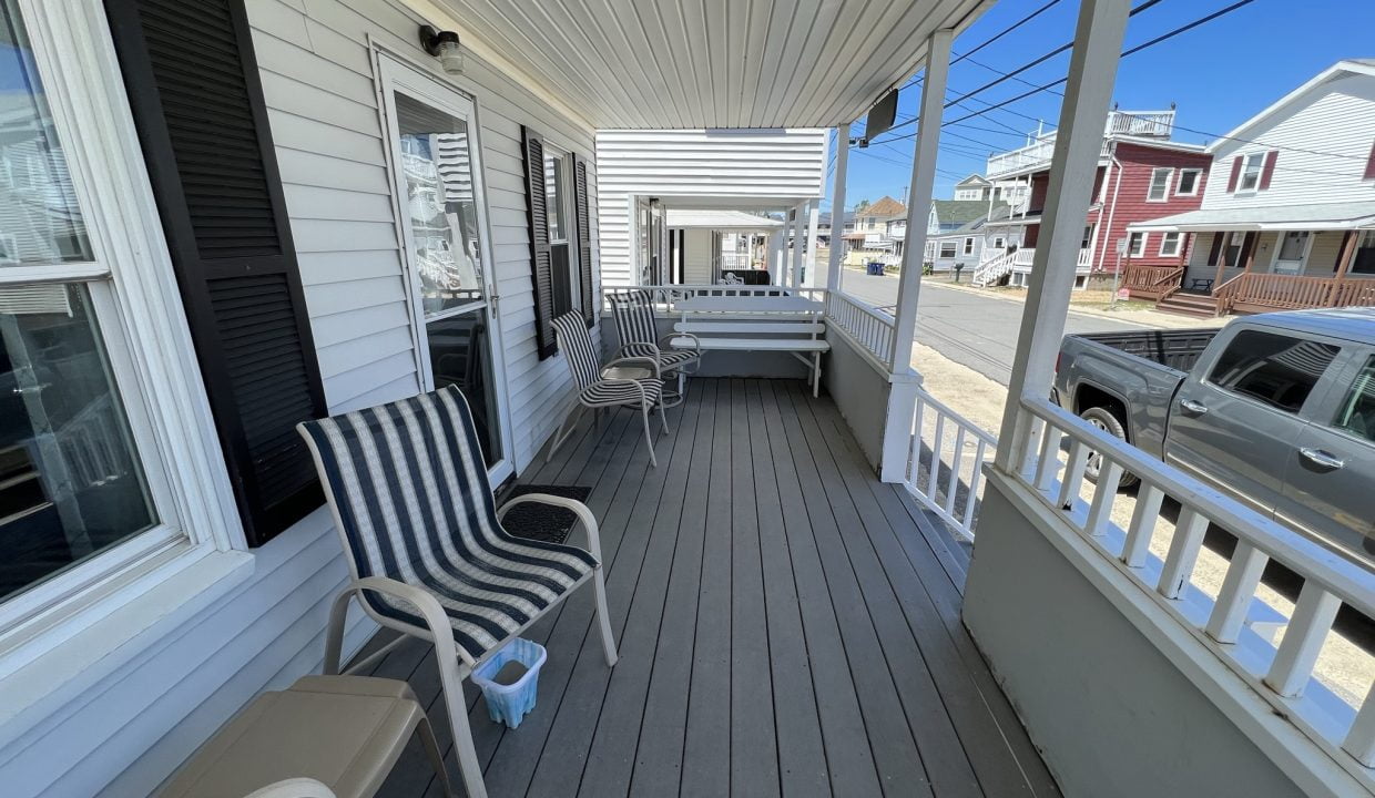 a couple of chairs sitting on top of a wooden porch.