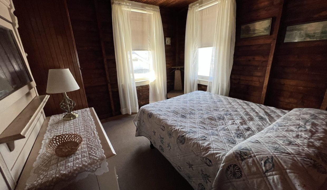 a bed room with a neatly made bed and a dresser.