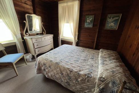 a bedroom with a bed, dresser and mirror.