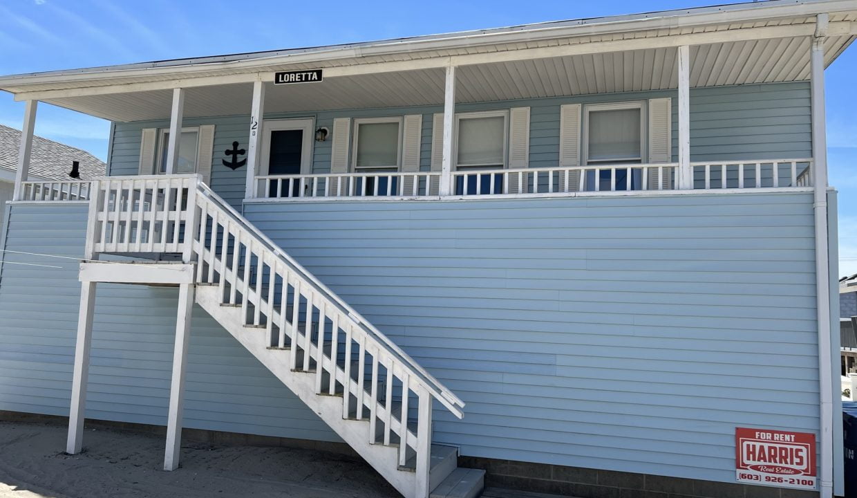 a blue house with a white staircase leading to the second floor.