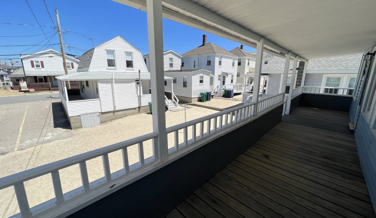 a porch with a view of a row of houses.