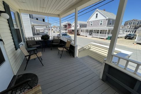 a porch with chairs and a television on it.