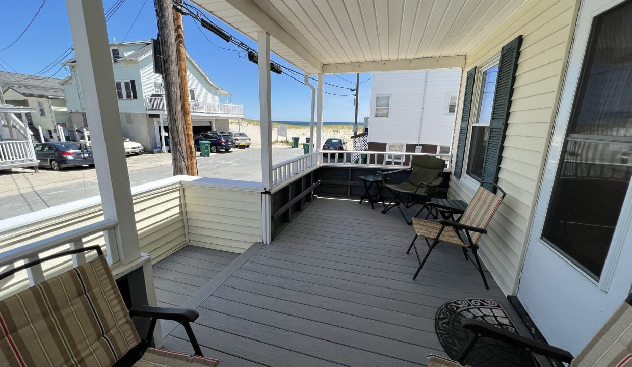 a porch with chairs and a table on it.