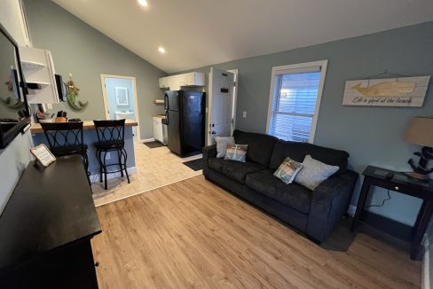 a living room filled with furniture and a kitchen.