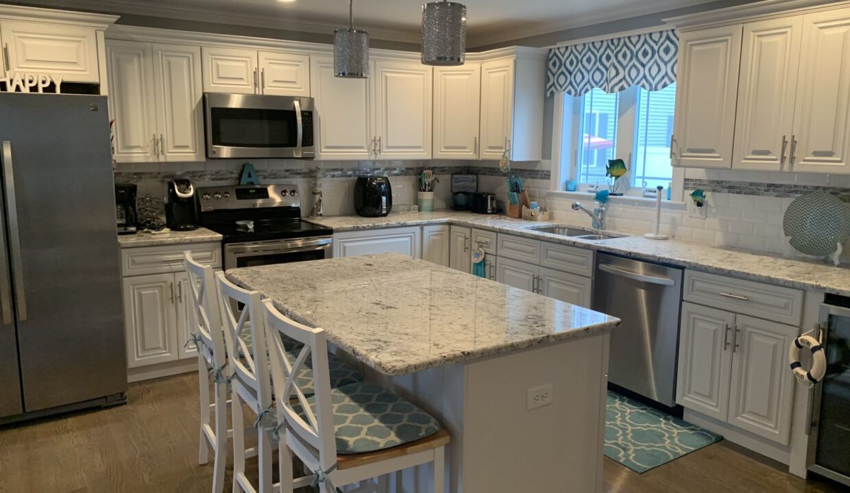 a kitchen with a center island with chairs.