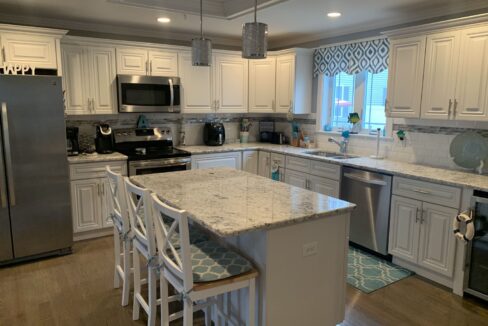 a kitchen with a center island with chairs.