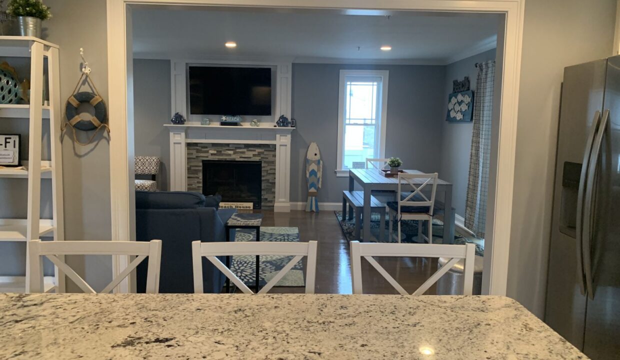 a kitchen with a table, refrigerator and a television.