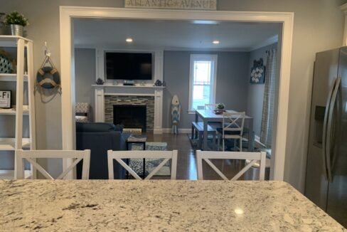 a kitchen with a table, refrigerator and a television.