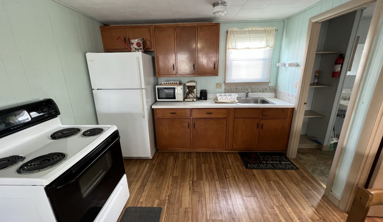 a kitchen with wood floors and white appliances.