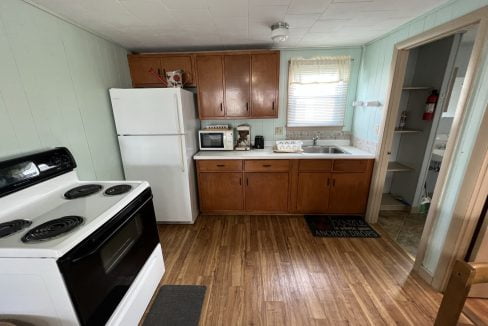 a kitchen with wood floors and white appliances.